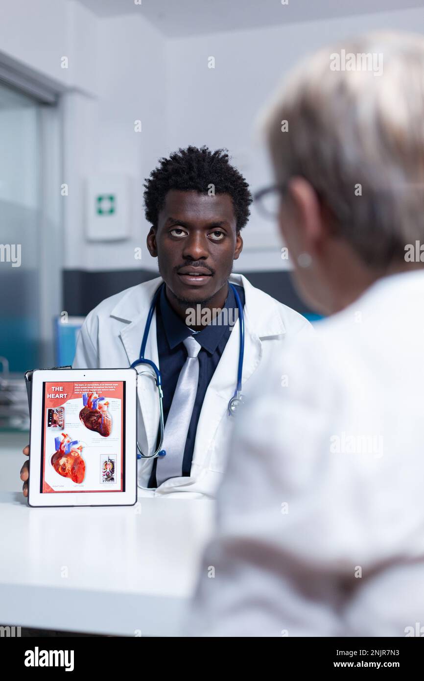 Cardiology doctor presenting heart problem and disease diagnostic to ...