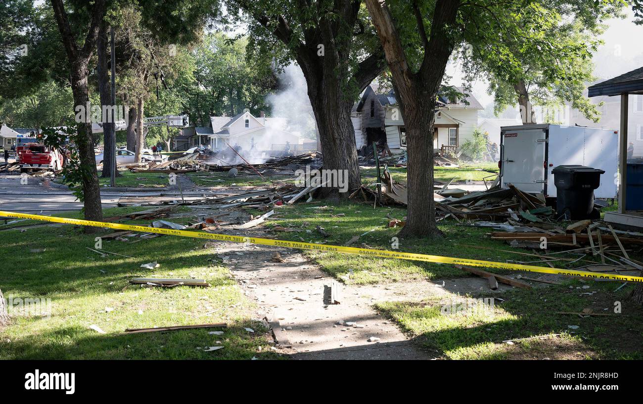 Firefighters and utilities crews work at the scene of an early morning