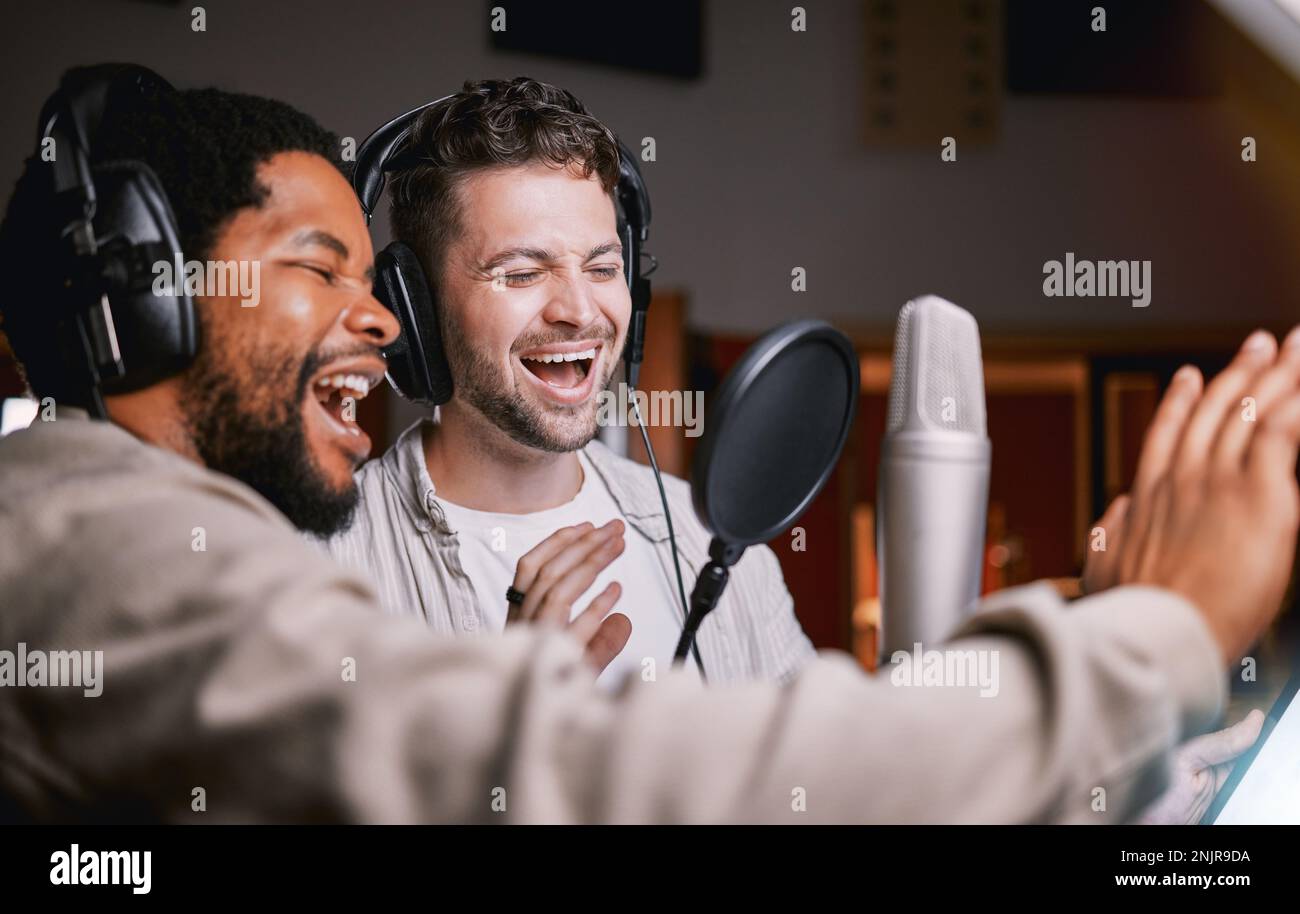 Team, men in recording studio singing and mic, sound equipment with music and artist, diversity and collaboration. Audio tech, headphones and musician Stock Photo
