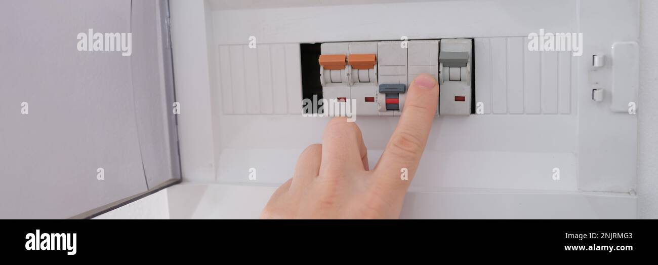Many switches displayed on circuit breaker board. Fnger is about to