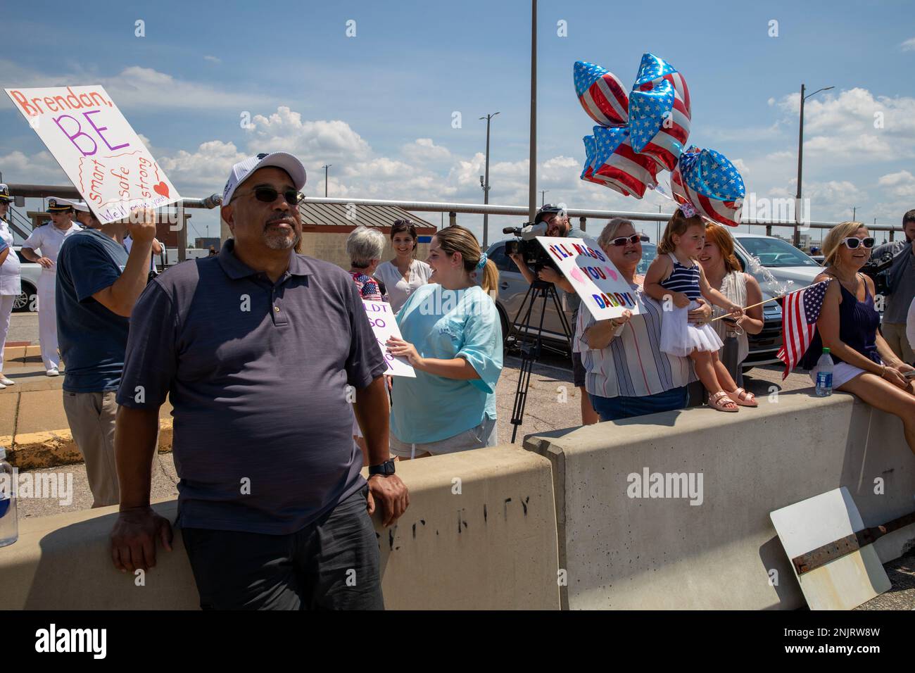 20220810-N-EL850 (Aug. 10, 2022) Families watch the Nimitz-class aircraft carrier USS George H.W. Bush (CVN 77) departing Naval Station Norfolk for a scheduled deployment Aug. 10, 2022.  George H.W. Bush provides the national command authority flexible, tailorable warfighting capability as the flagship of a carrier strike group that maintains maritime stability and security to ensure access, deter aggression and defend U.S., allied and partner interests. Stock Photo