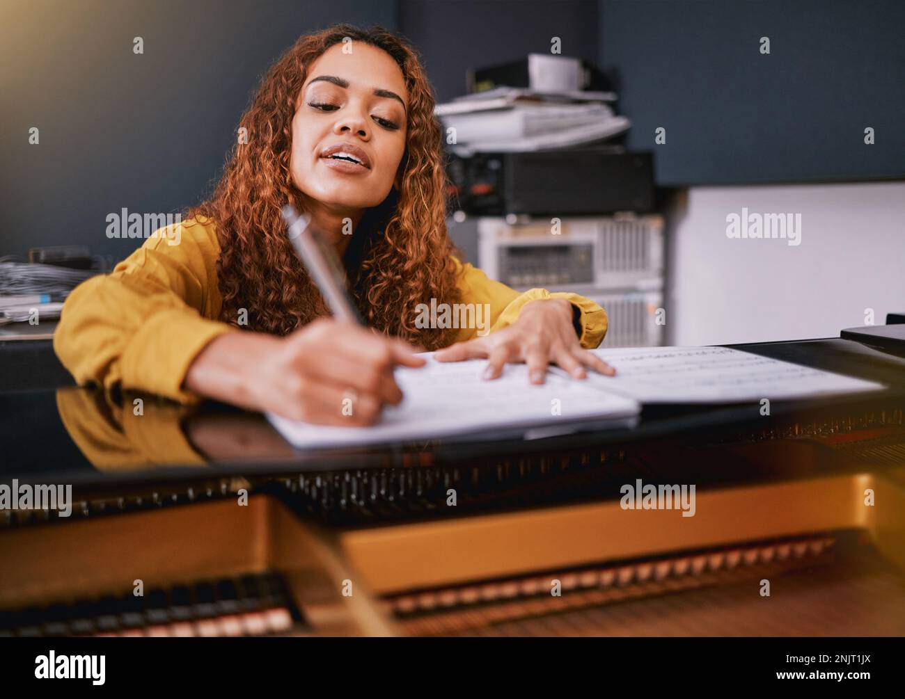 Musician, paper or song writing on piano in recording studio for album