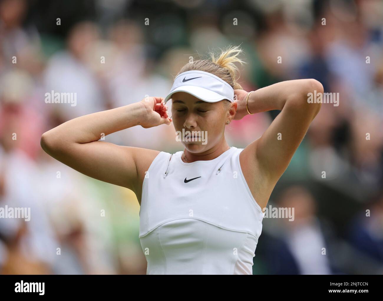 Amanda Anisimova of United States of America fixes her hair during the game of the ladies singles quarter-finals match against Simona Halep of Romania in the Championships, Wimbledon at All England Lawn