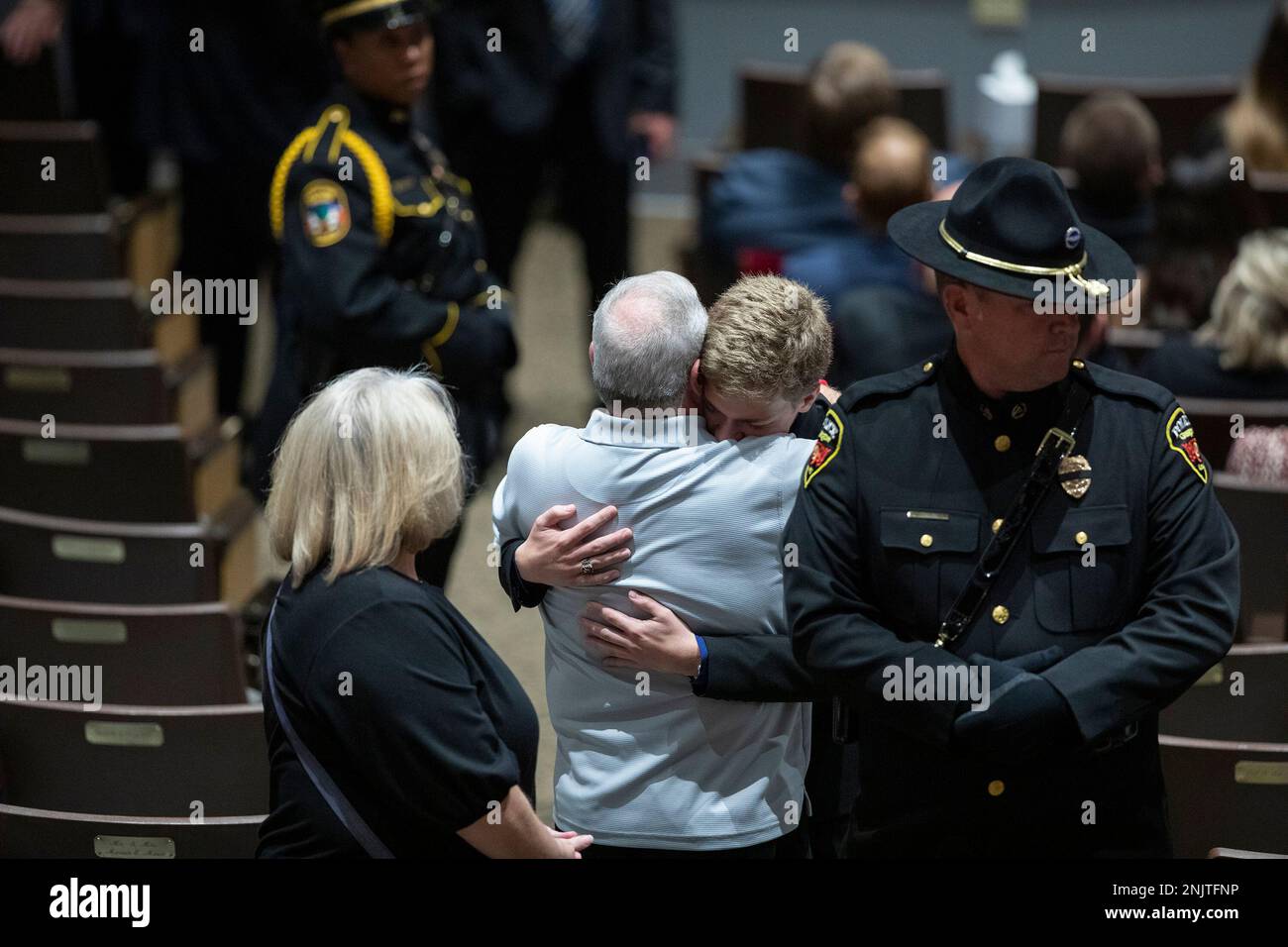 Family members embrace during the funeral for Floyd County Deputy William Petry at the Mountain