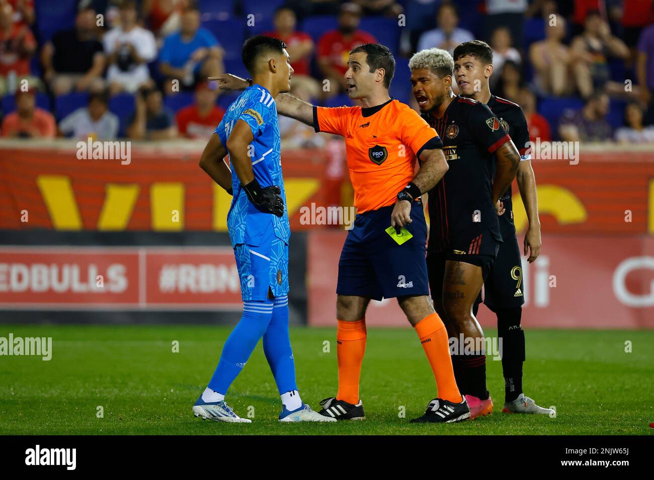 HARRISON, NJ - JUNE 30: Referee Alex Chilowicz issues a yellow card to  Atlanta United goalkeeper Rocco Ríos Novo (34) during the second half of  the Major League Soccer game between the