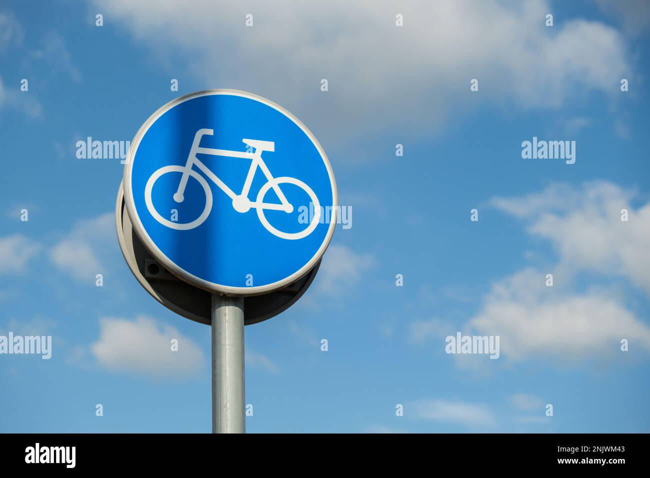 Round road sign depicting white bicycle on blue background, meaning