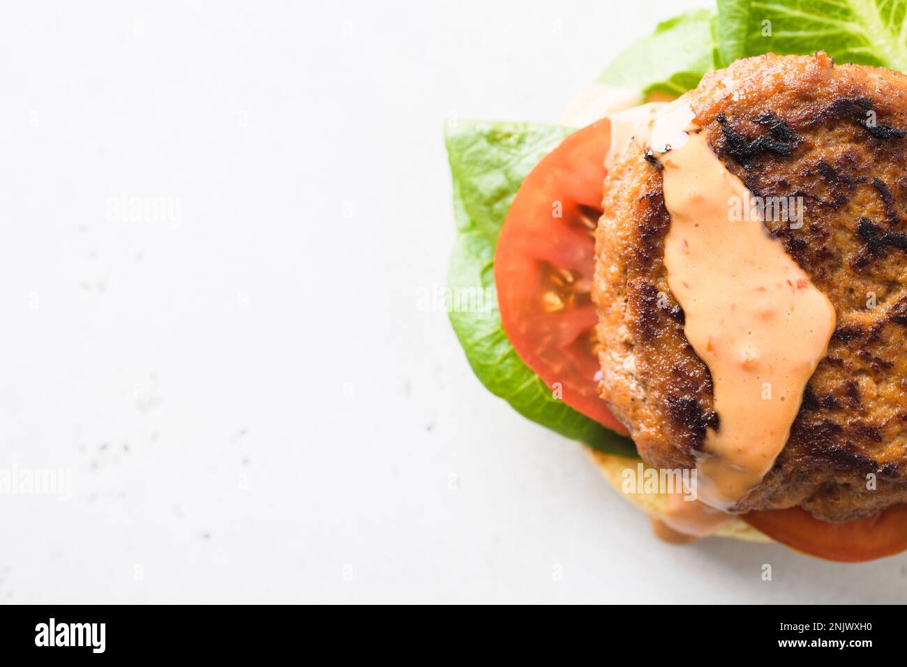 This image released by Milk Street shows a recipe for Smoky ChiliGarlic Pork Burgers. (Milk