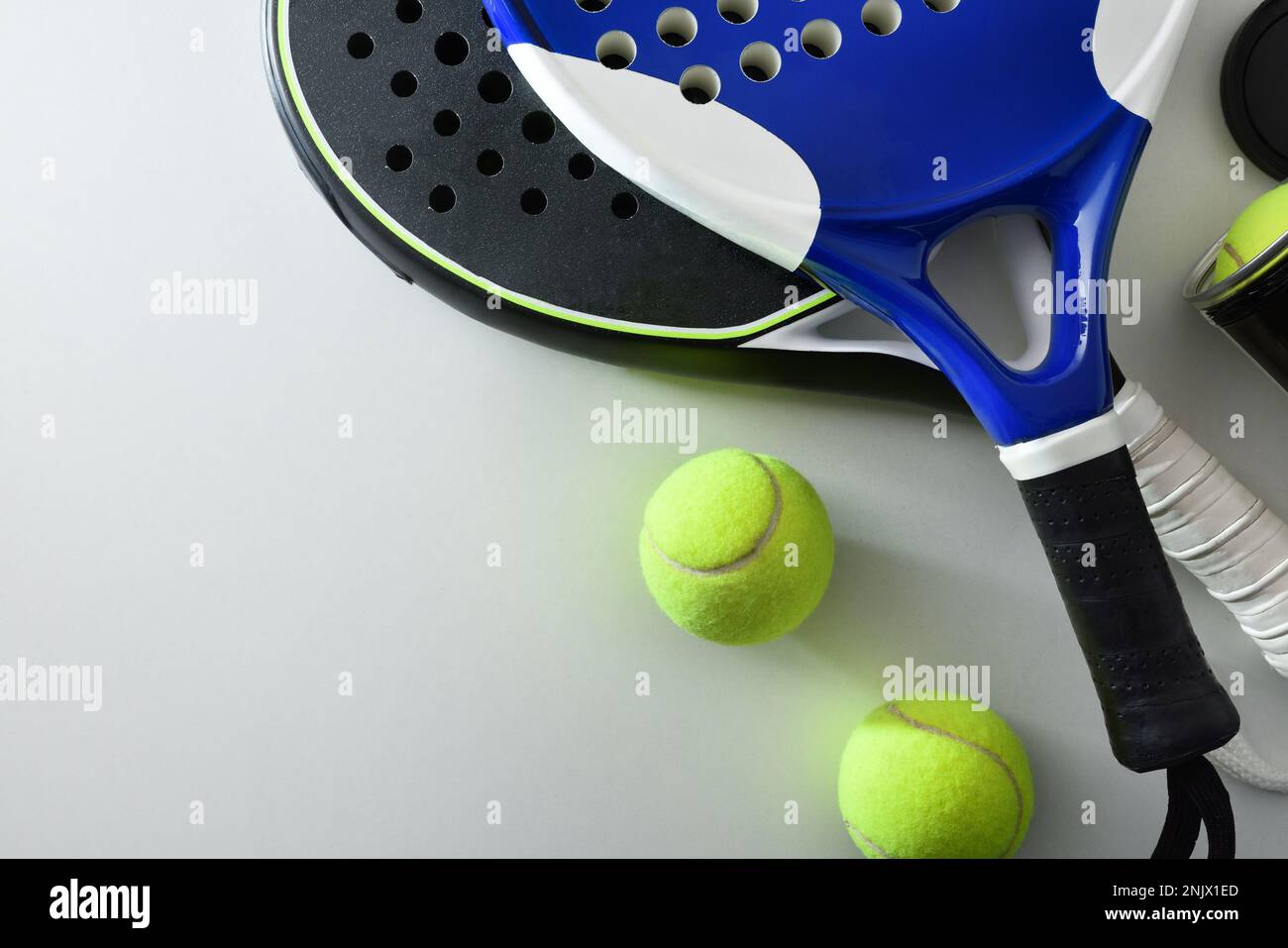 Two paddle tennis rackets and set of balls on white table. Top view. Stock Photo