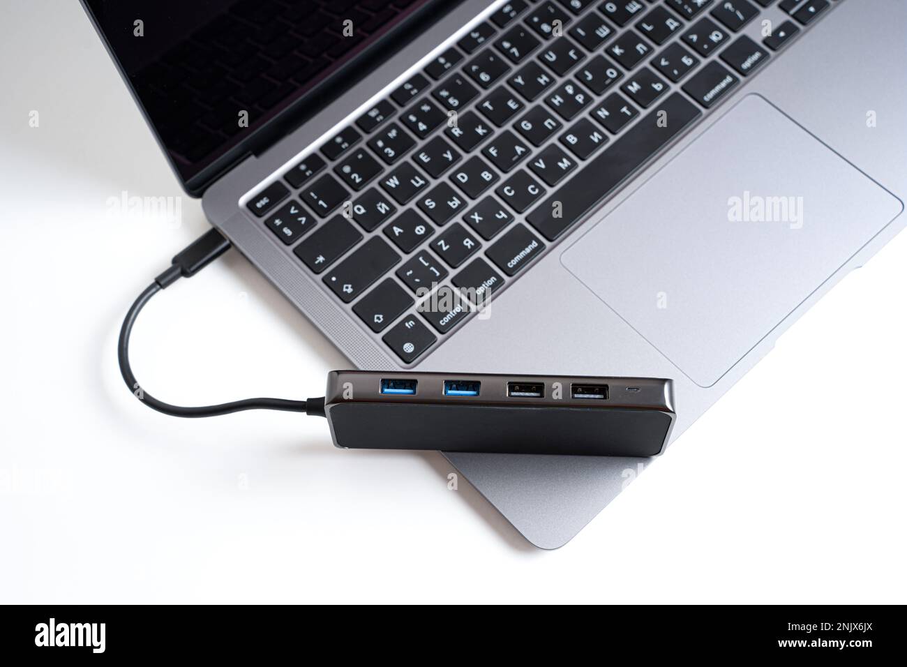 Top view of a multiport usb expansion adapter placed on a laptop isolated on white background. Professional connectivity solutions for modern computer Stock Photo