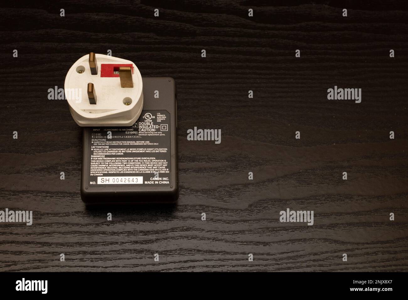 Rear of a Canon camera battery charger connected to a British 13amp