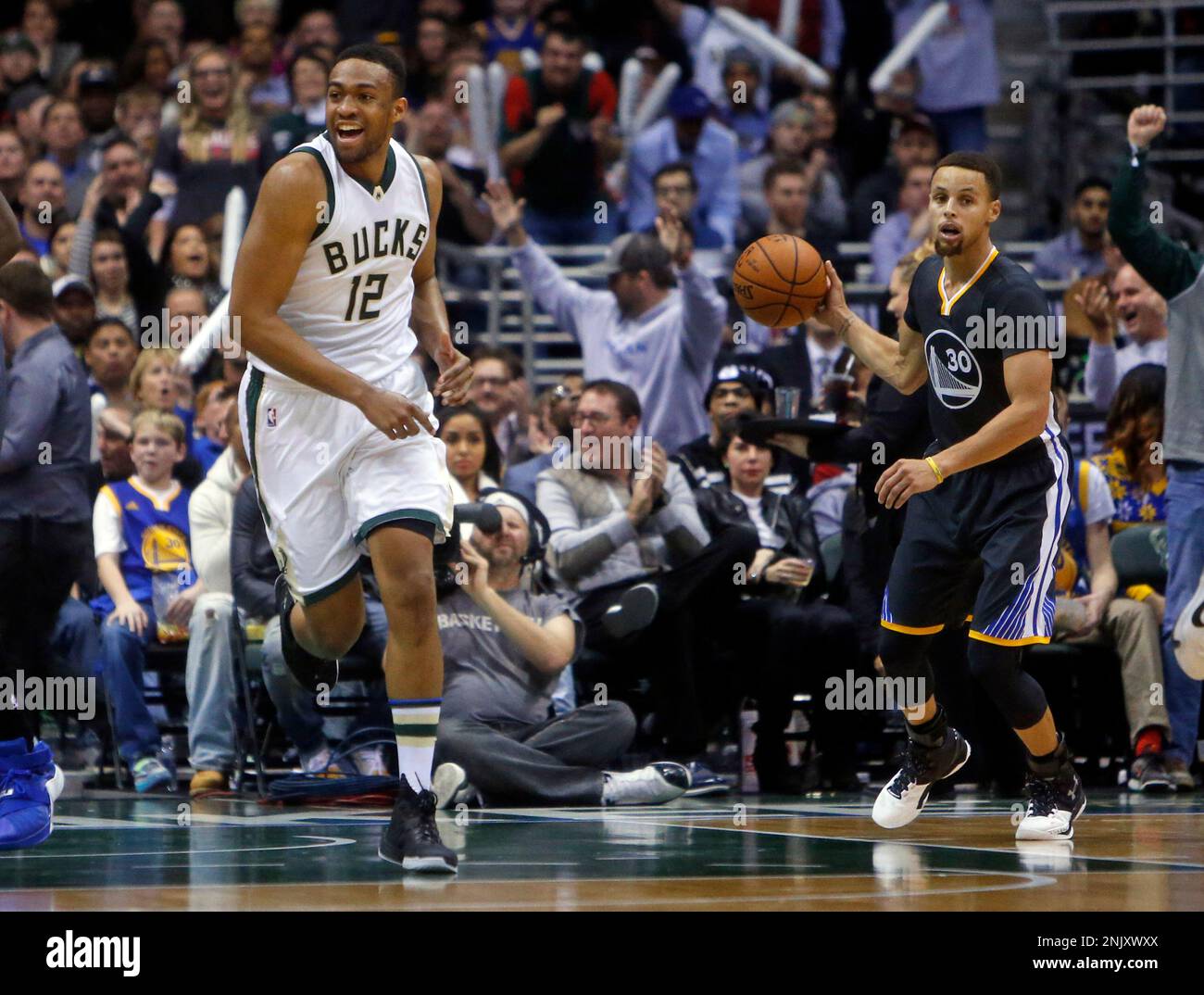 Milwaukee Bucks' Jabari Parker celebrates a basket as Golden State  Warriors' Stephen Curry gets the ball during Milwaukee's 108-95 win in NBA  game at BMO Harris Bradley Center in Milwaukee, WI on, image size:1300x1074