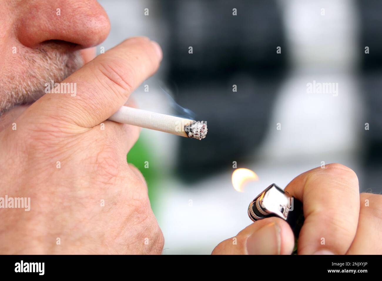 man lighting a cigarette, side view Stock Photo Alamy