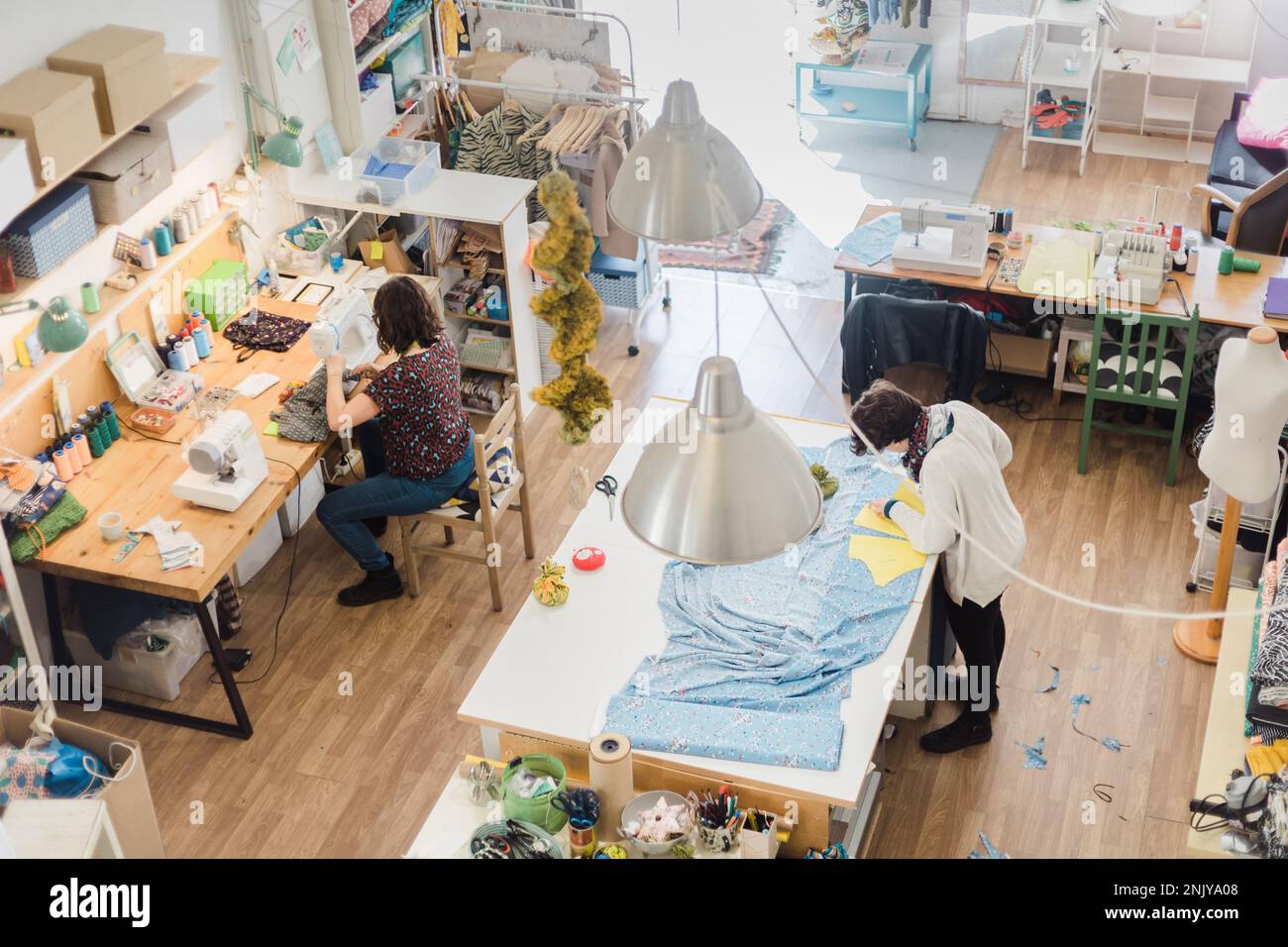 High angle of female tailors working with fabric together while creating creative patterns in workshop Stock Photo