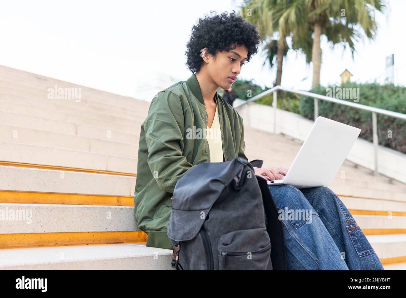 From below concentrated young ethnic male student in casual clothes ...