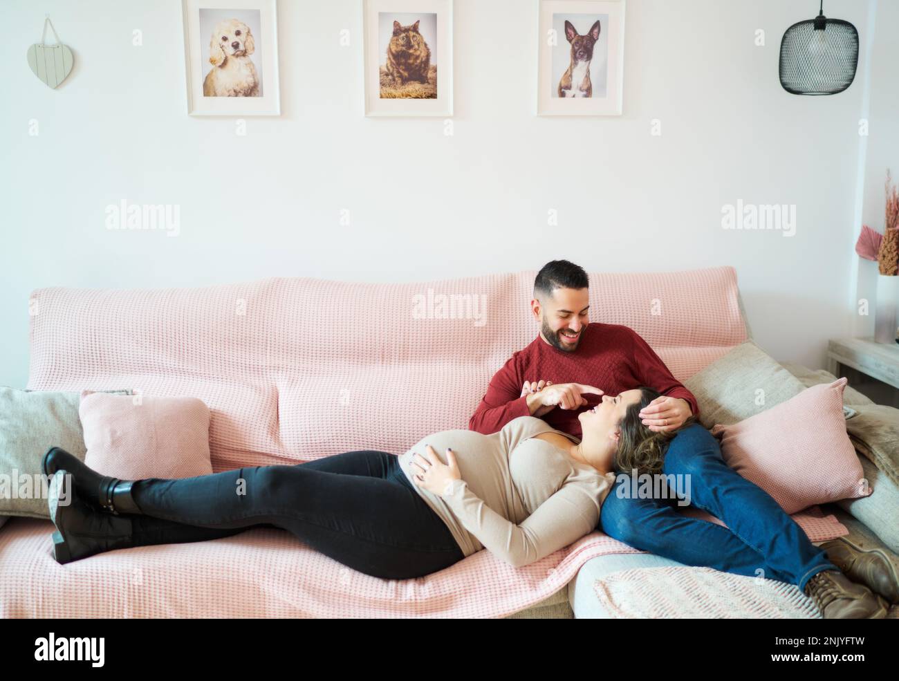 https://c8.alamy.com/comp/2NJYFTW/loving-man-in-casual-clothes-sitting-with-pregnant-woman-lying-down-looking-at-each-other-on-comfortable-sofa-at-home-2NJYFTW.jpg