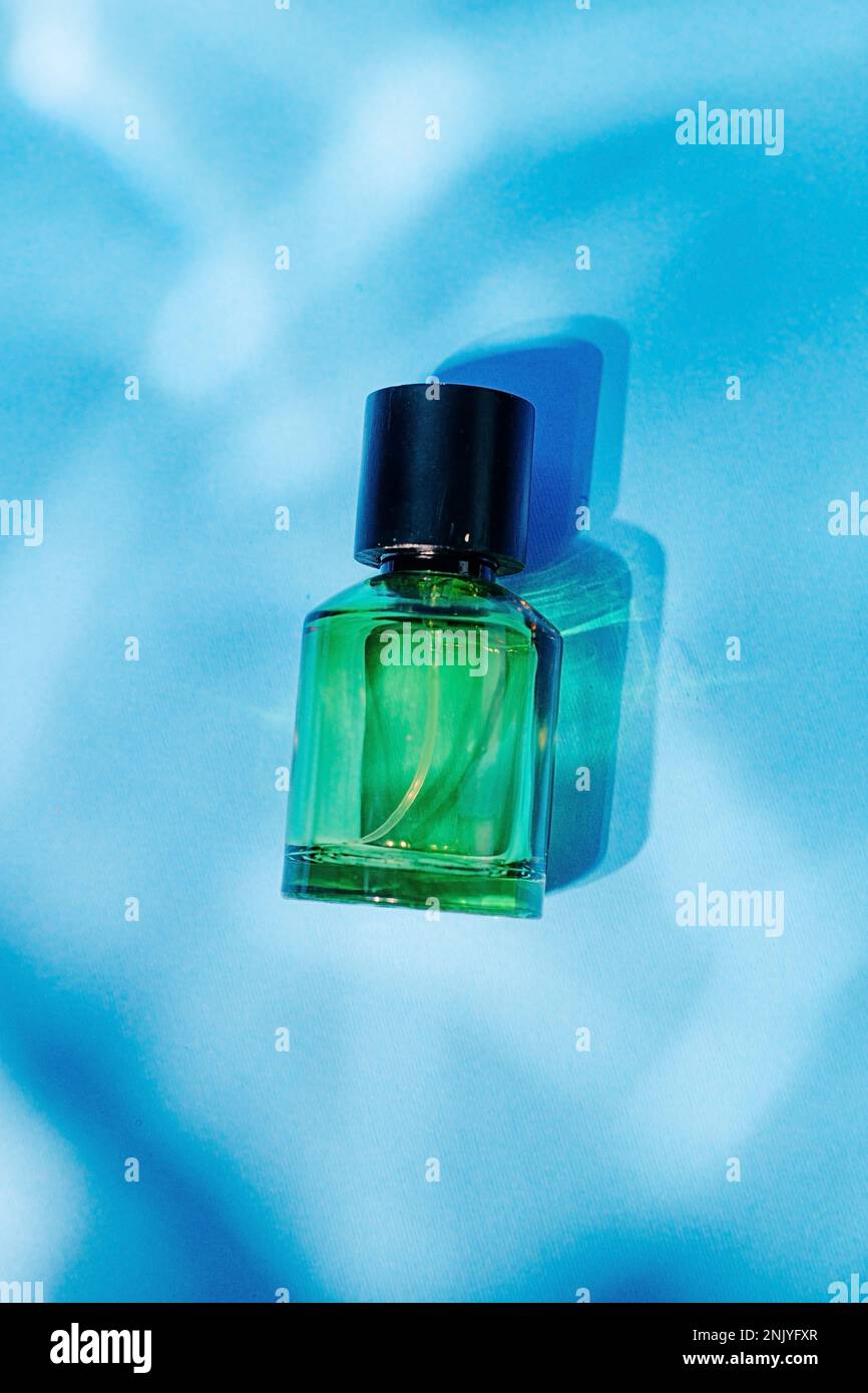 Green glass transparent empty container placed on blue background Stock Photo