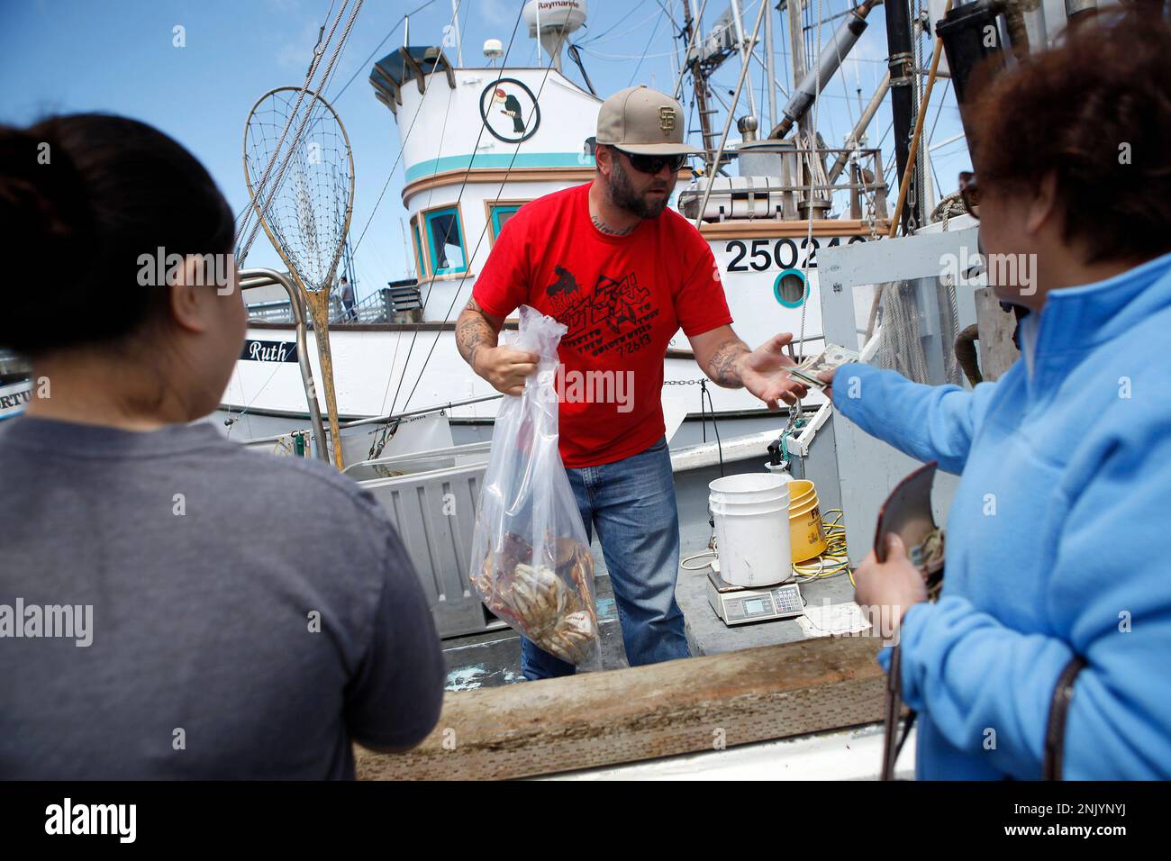 Fisherman Devin Bunch sells dungeness crab to customers from the boat