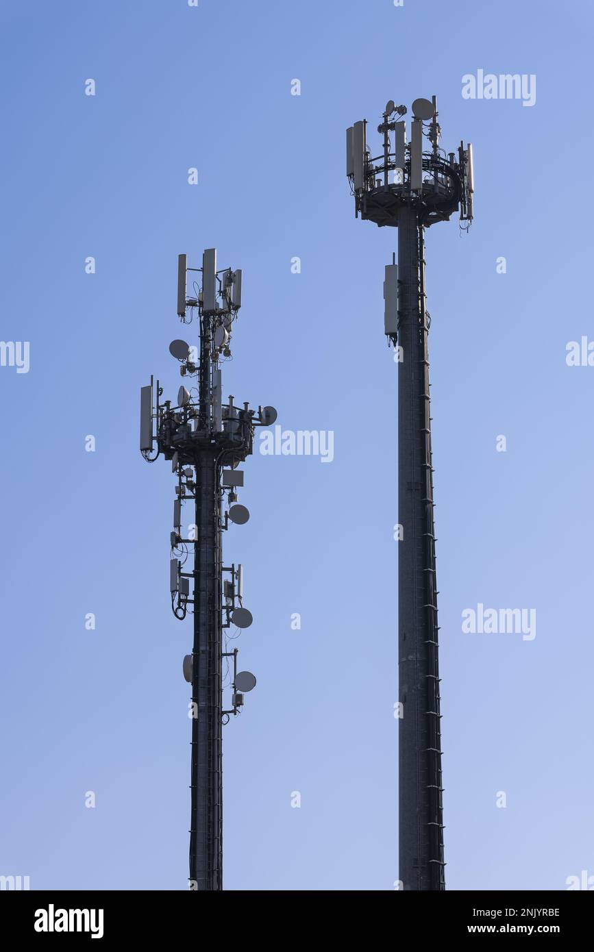 Telecommunications tower with cellular antennas and repeaters against a clear blue sky (Vertical photos) Stock Photo