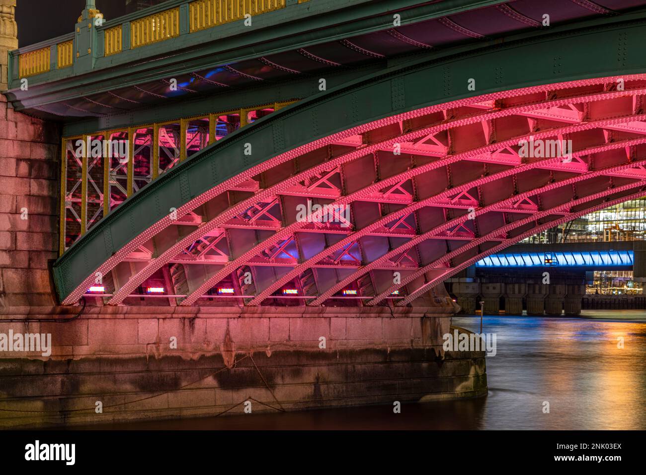Underneath Southwark Bridge over the River Thames at night, London, England, UK Stock Photo