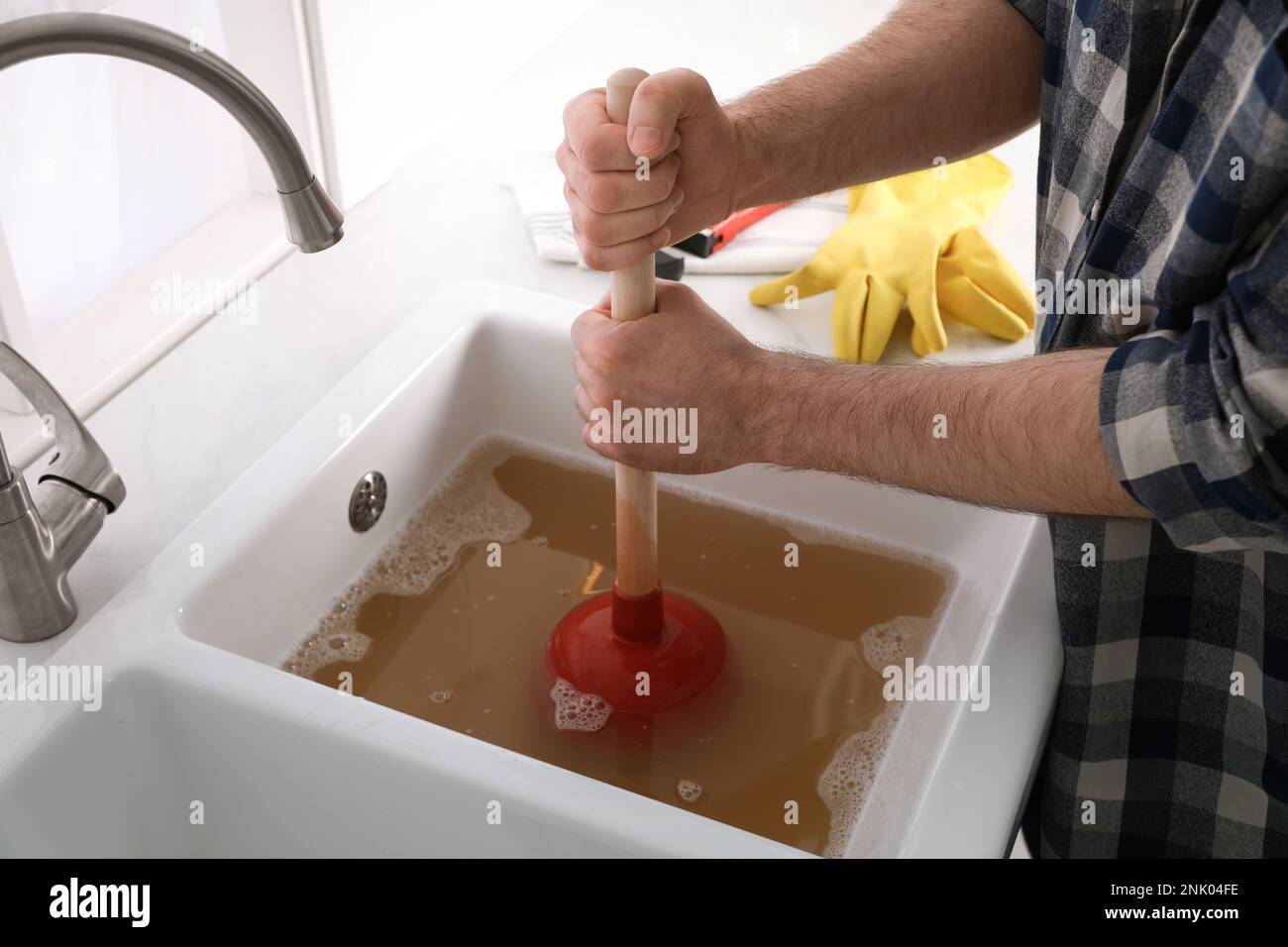 Closeup Of Man Using Plunger In Kitchen Sink Stock Photo, Picture and  Royalty Free Image. Image 23490896.