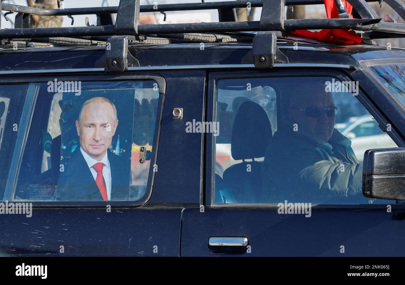A view shows a poster of Russian President Vladimir Putin attached to a car before the start of an automobile rally marking Russia's Defender of the Fatherland Day in the course of Russia-Ukraine conflict in Luhansk, Russian-controlled Ukraine, February 23, 2023. REUTERS/Alexander Ermochenko Stock Photo