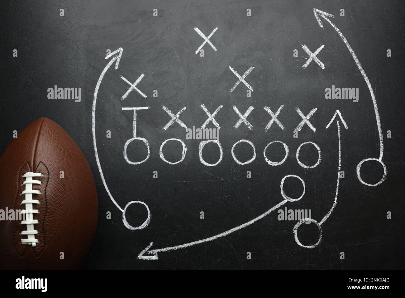 Rugby ball and drawn American football strategy game on black