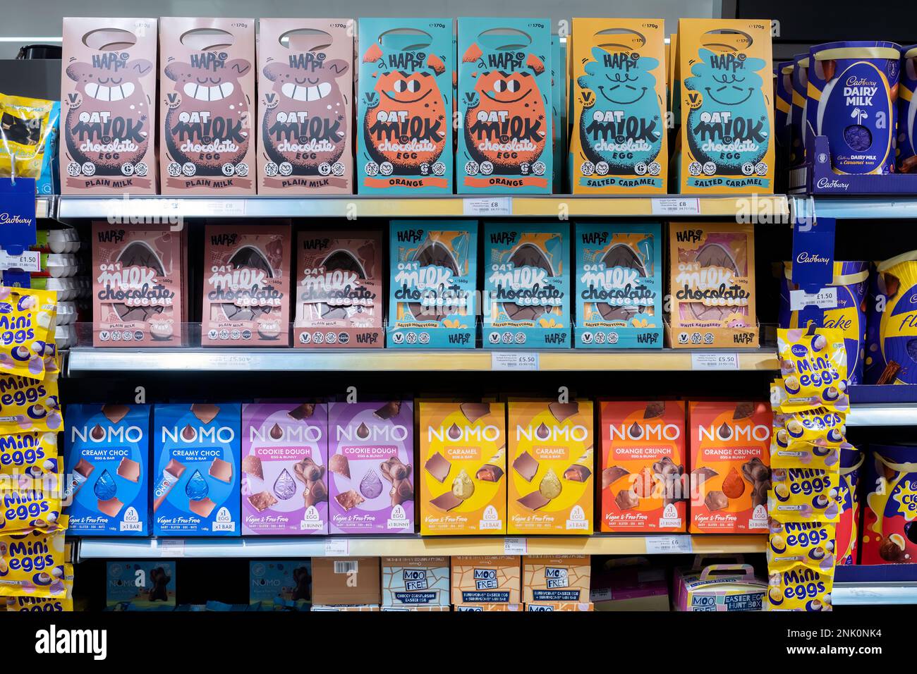 A UK supermarket shelf display of specialist vegetarian and vegan friendly chocolate Easter Eggs. The brands shown include Happi and Nomo Stock Photo