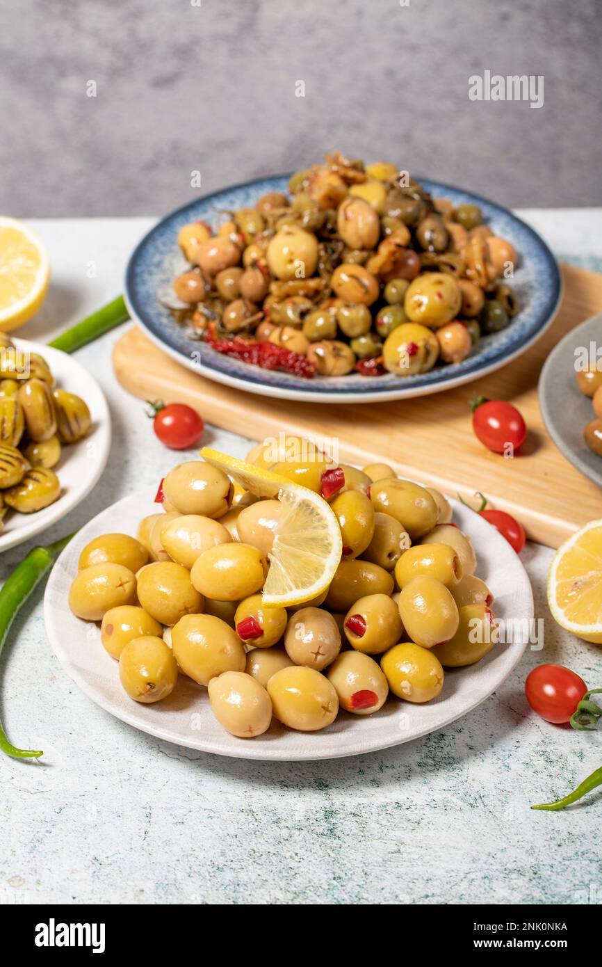Olive varieties. Assortment of black and green olives on plate on gray background. Close up Stock Photo
