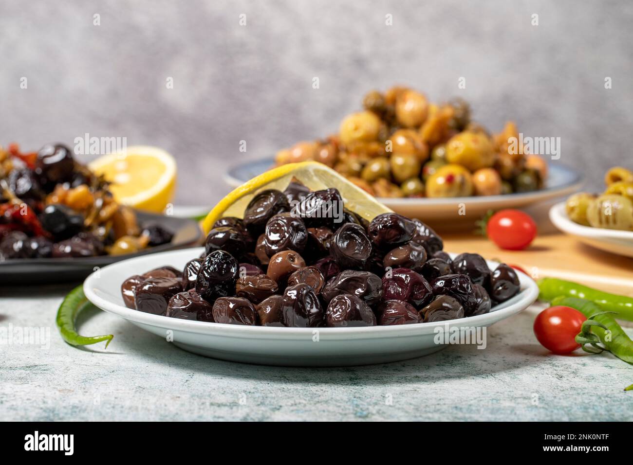 Olive varieties. Assortment of black and green olives on plate on gray background. low angle view Stock Photo
