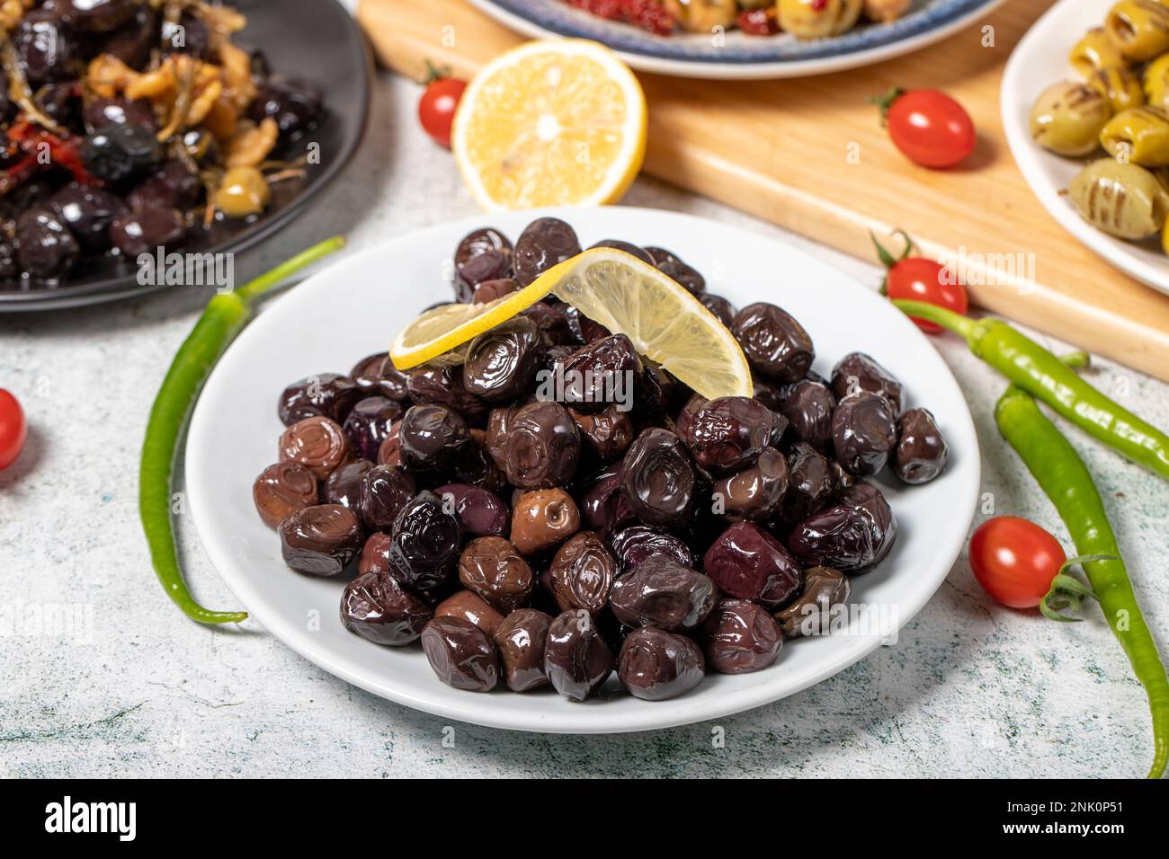 Olive varieties. Assortment of black and green olives on plate on gray background. Close up Stock Photo