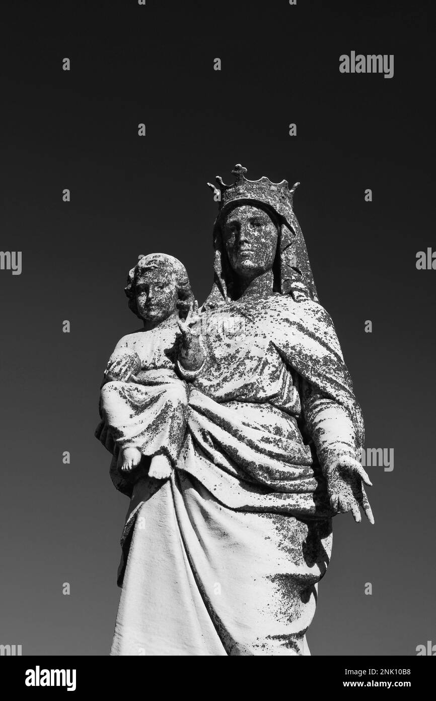 A crowned Vi4]rgin Mary holding her young son, Jesus Christ in a black ...