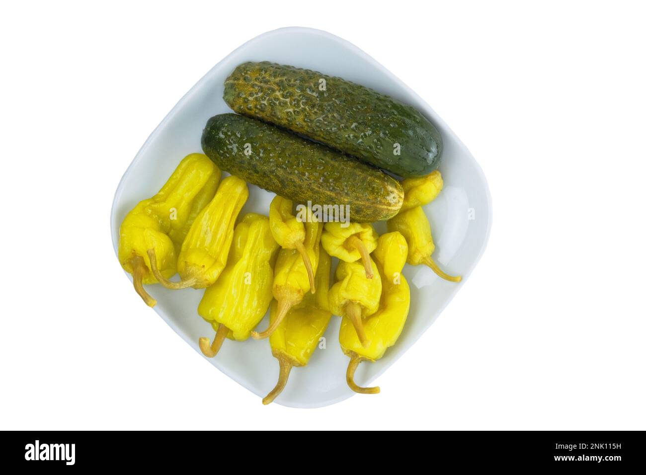 Pickled cucumbers and peppers on a plate. Fermented vegetables home cooking. Isolate on a white background. Stock Photo
