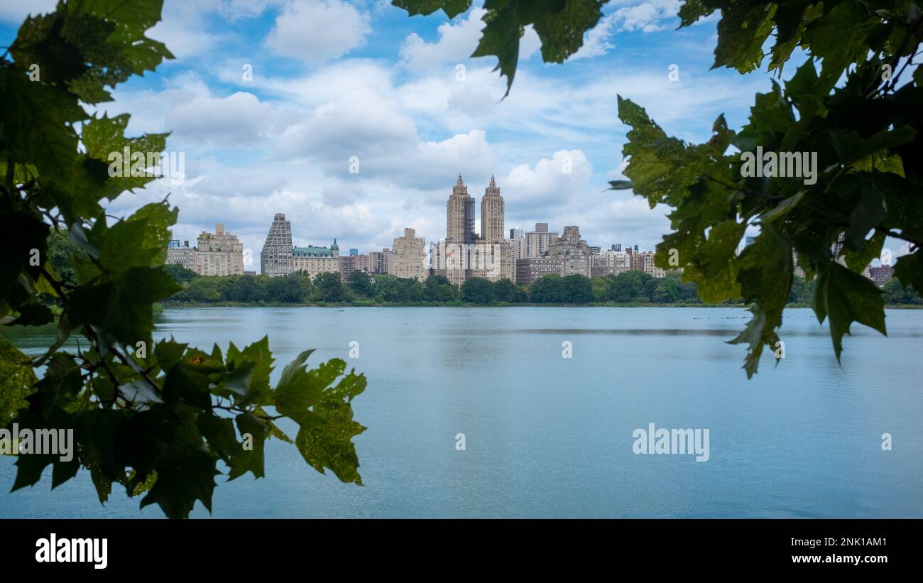 Foliage framed view of the El Dorado cooperative apartment building overlooking the Jacqueline Kennedy Onassis Reservoir of Central Park, NYC. Taken o Stock Photo