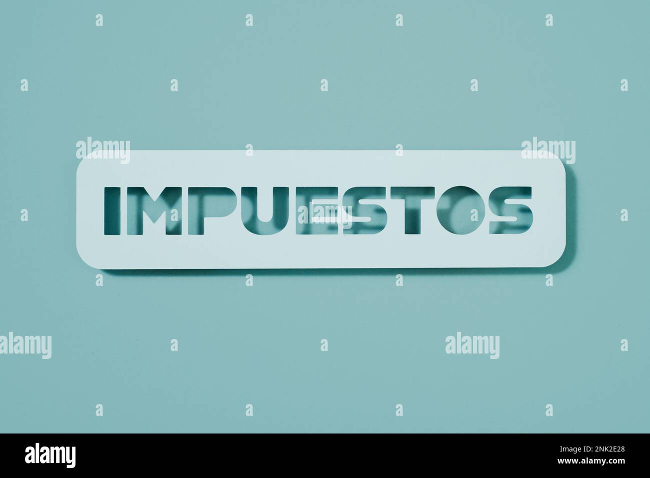 a pale blue paper sign with the text taxes written in spanish, on a