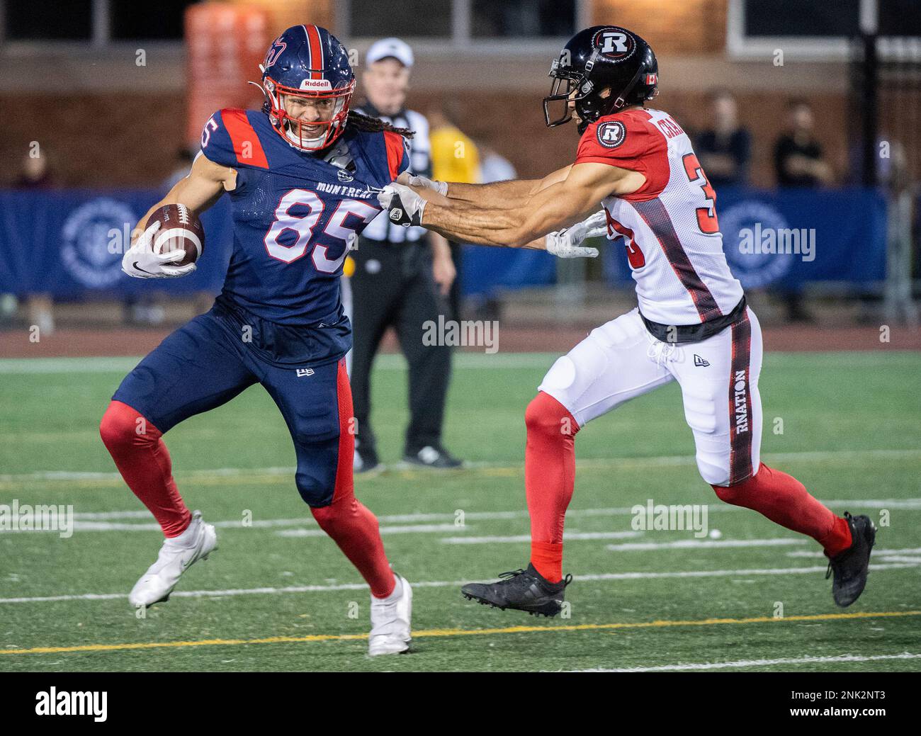 Montreal Alouettes wide receiver Krishawn Hogan (85) holds off a tackle by  Ottawa Redblacks' Ty Cranston during the second half of a Canadian Football  League preseason game Friday, June 3, 2022, in