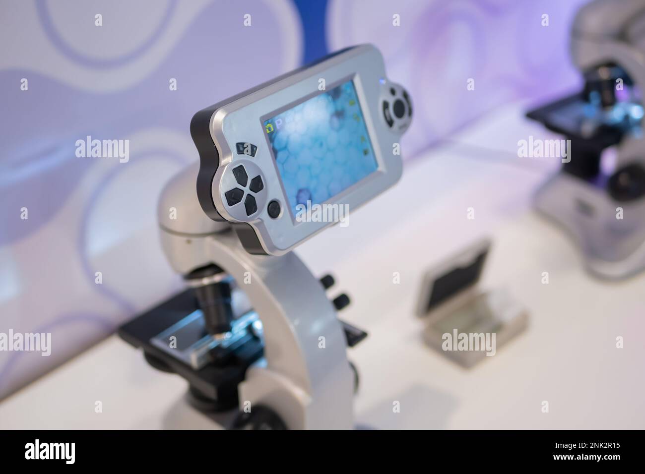 Microscopes with display and control buttons on white table - close up ...