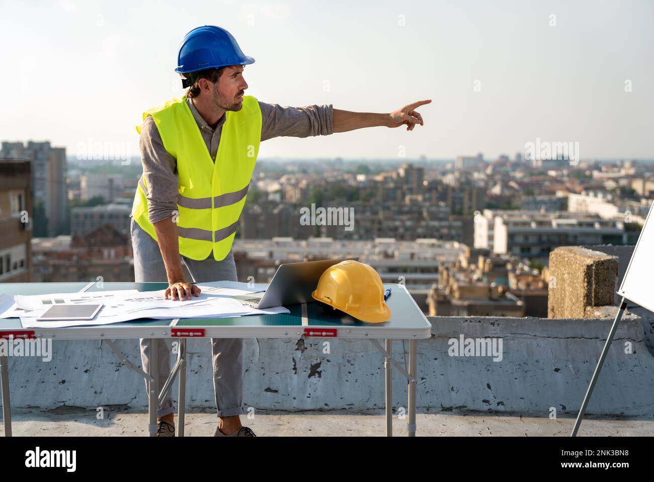 Young businessman construction site engineer working with architect blueprints on construction site. Stock Photo