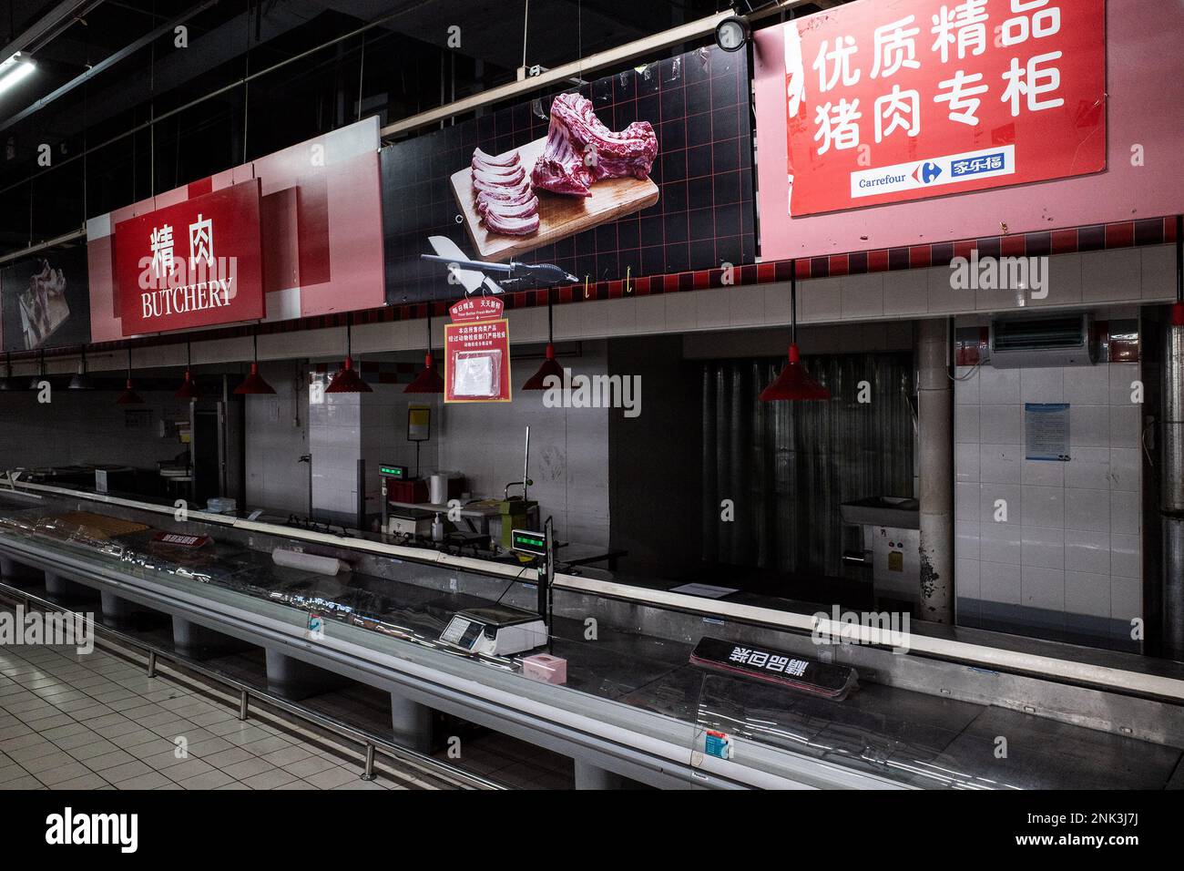 The butchers section has been cleared at a Carrefour store in Wuhan. Carrefour entered the Chinese market in the year 1995 and expanded very quickly, securing a large market share. However earnings began to get smaller as the competition kept on increasing. In the year 2019, the French retailer sold around 80% of its 'loss-making' China business to Jiangsu-based 'Suning' for CNY 4.8 billion which was equal to USD 699 million at the time).This month, reports of shortages at the many local Carrefour store have caught the attention of customers. Several people started complaining that they have b Stock Photo