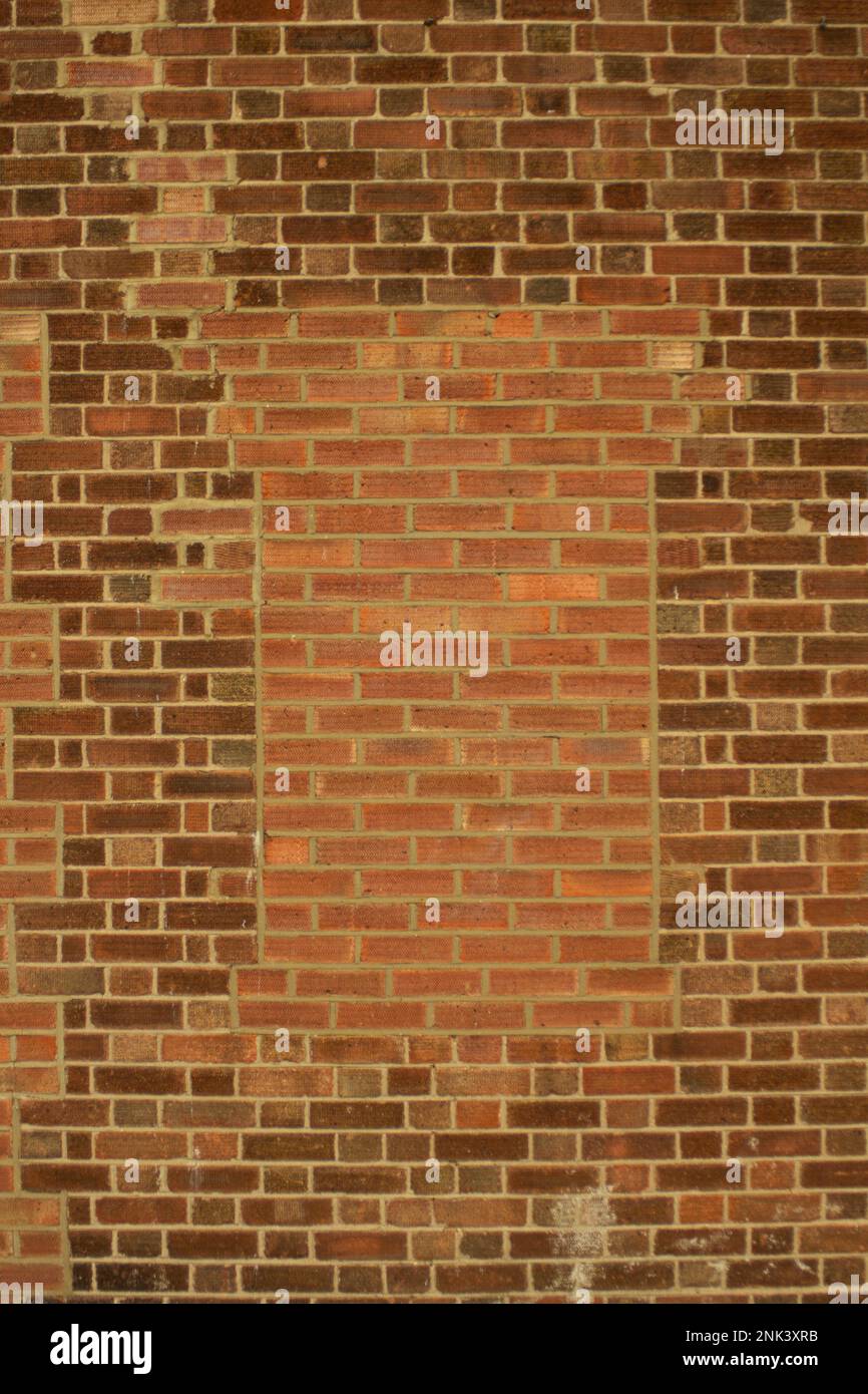A bricked in arch in a brick wall, Suitable for use as a framing device with space for text Stock Photo