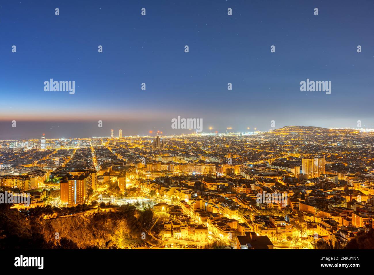 The skyline of Barcelona with the Mediterranean Sea in the back at night Stock Photo