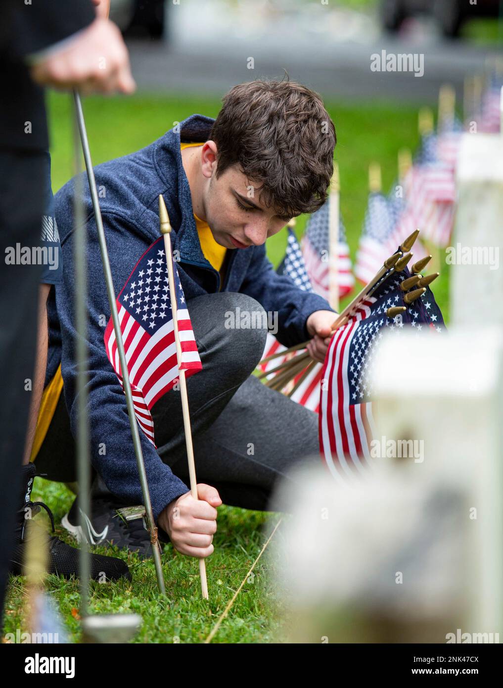 Greenwood High School JROTC Seaman Ayden Wilson helps place flags with ...