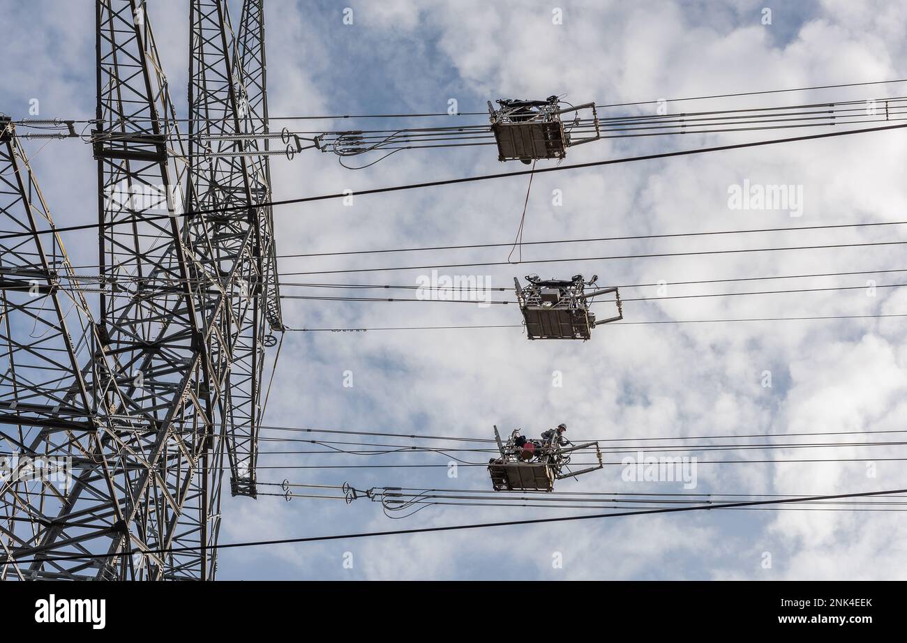 A newly installed high-voltage pylon with some cables connected Stock Photo