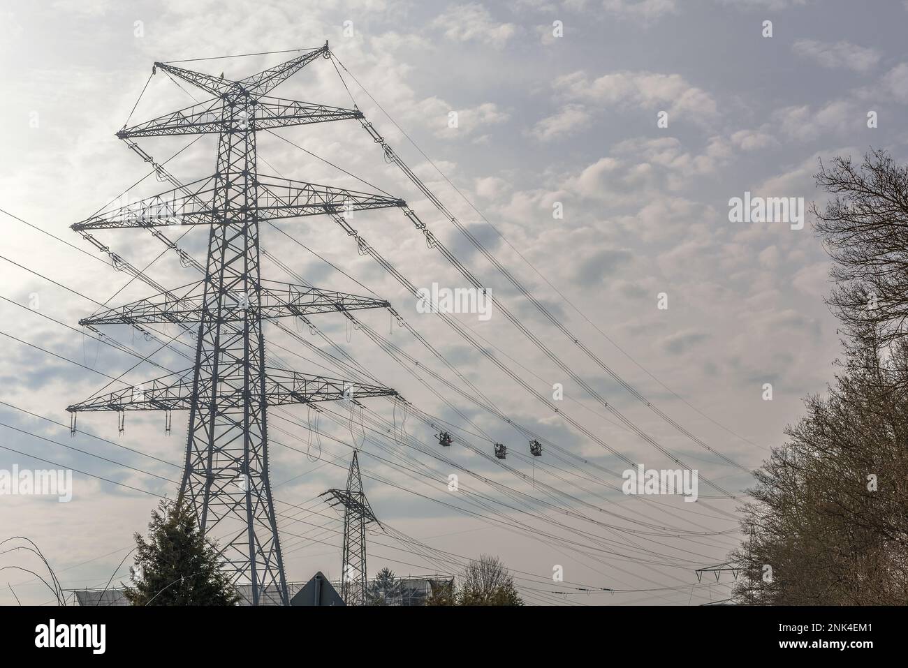 A newly installed high-voltage pylon with some cables connected Stock Photo