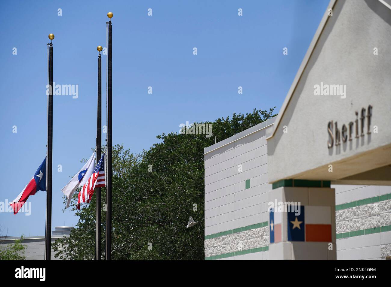 Flags fly at half staff at the Ector County Sheriff's Office in Odessa