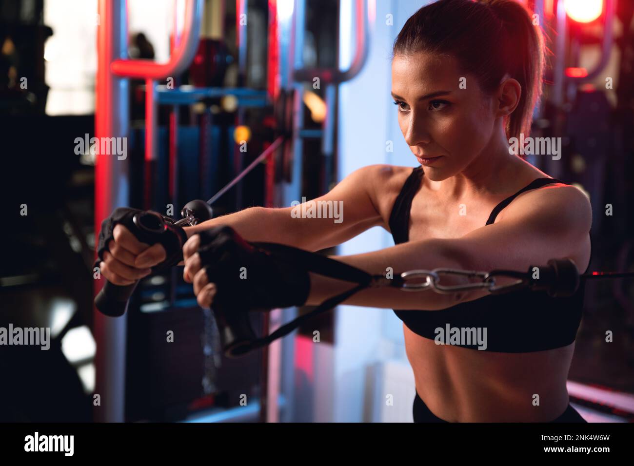 https://c8.alamy.com/comp/2NK4W6W/portrait-of-a-30s-woman-working-out-chests-on-a-cable-machine-2NK4W6W.jpg