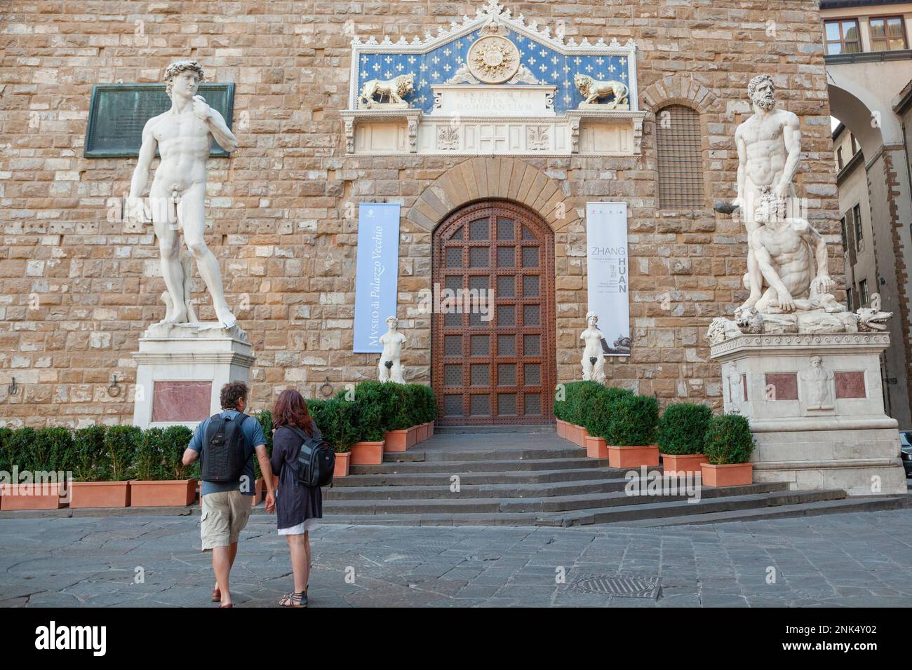 A tourist couple admire the ancient marble statues outside of the Museo di Palazzo Vecchio in Florence, Tuscany, Italy. Stock Photo