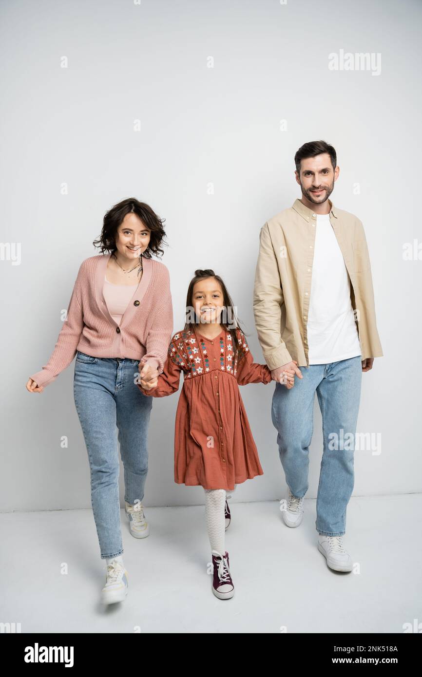 Portrait Of Happy Family Walking Over White Background Against