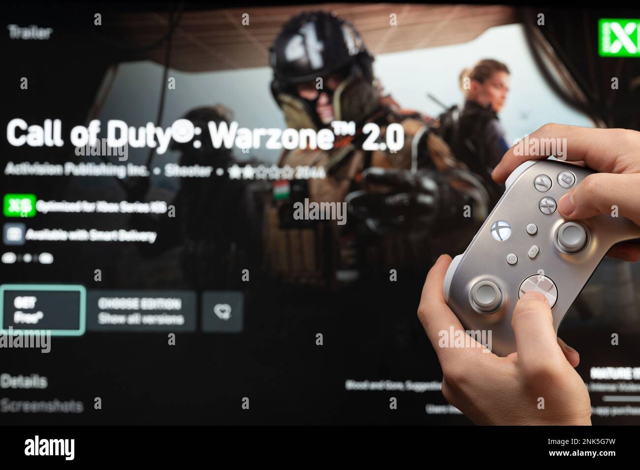 New york, USA - February 20, 2023: Play Call of Duty Warzone console game on TV Xbox with joystick in hand close up view Stock Photo