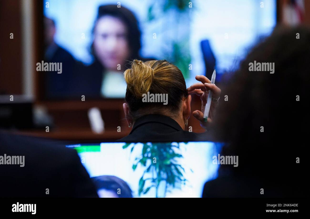 Actor Johnny Depp reacts as Raquel Pennington testifies during a previously  recorded video deposition at the Fairfax County Circuit Courthouse in  Fairfax, Va., Wednesday, May 18, 2022. Actor Johnny Depp sued his