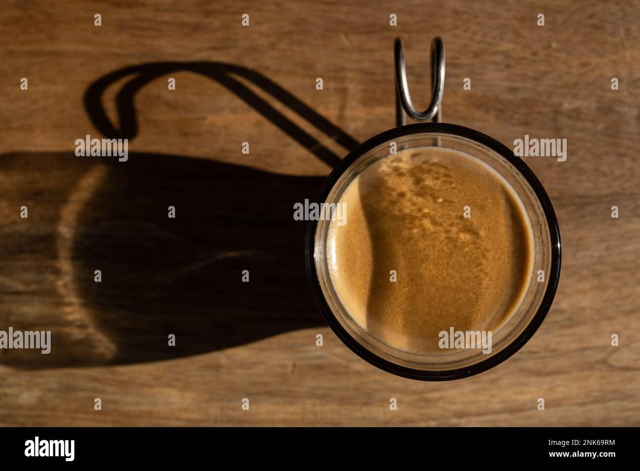 A shot of espresso in a small glass with metal handle Stock Photo